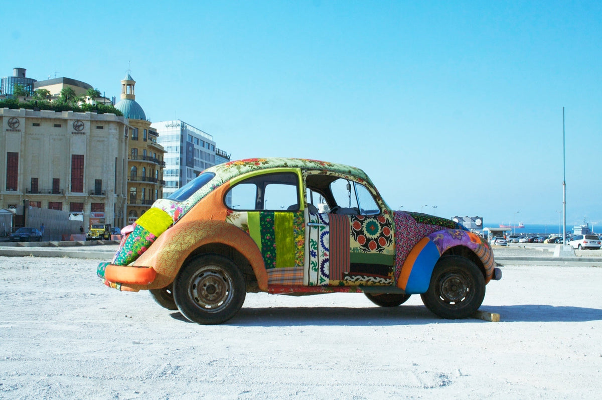A dilapidated Beetle, dressed in a patchwork of clashing fabrics