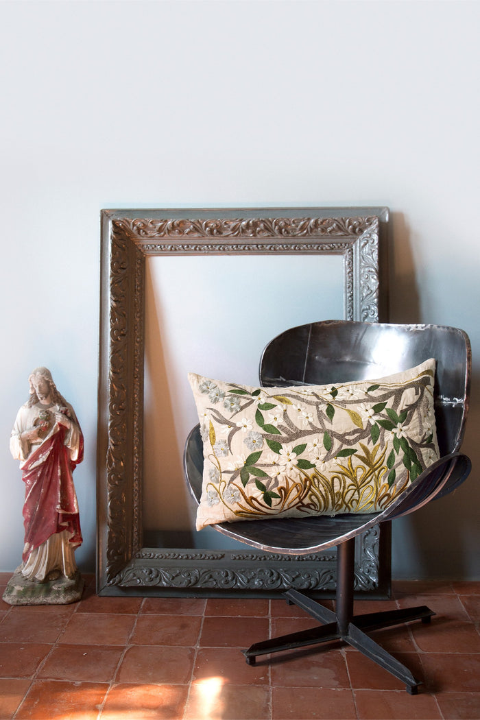 Primavera embroidered cushion styled with an antique frame and a painted statue